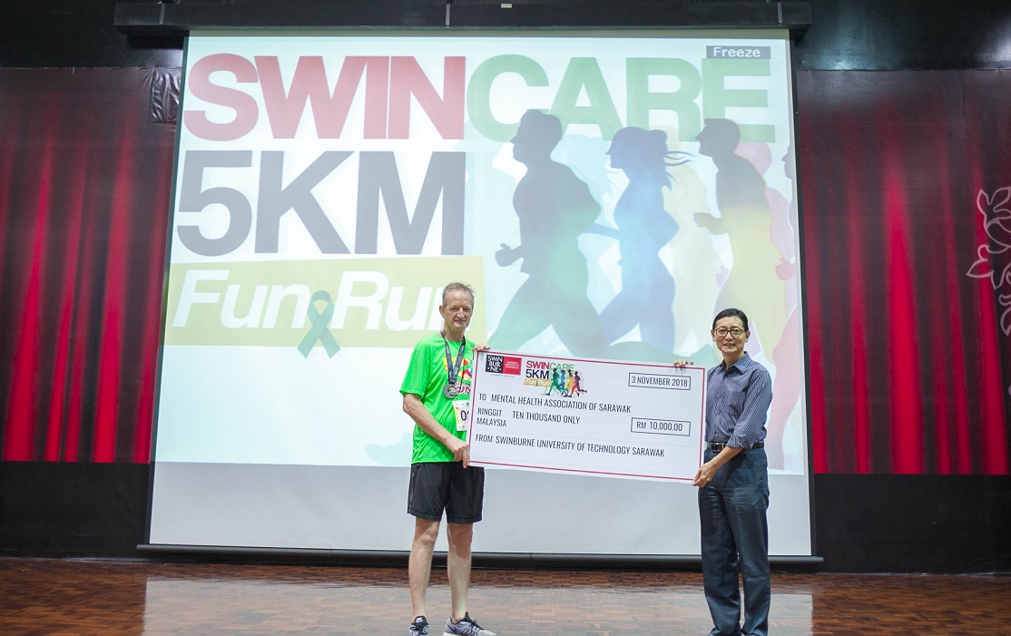 Professor Wilson (left) presenting a mock cheque to Deputy Chairperson of MHAS Kuching Branch Dr Lau Kim Kah at the end of the event.