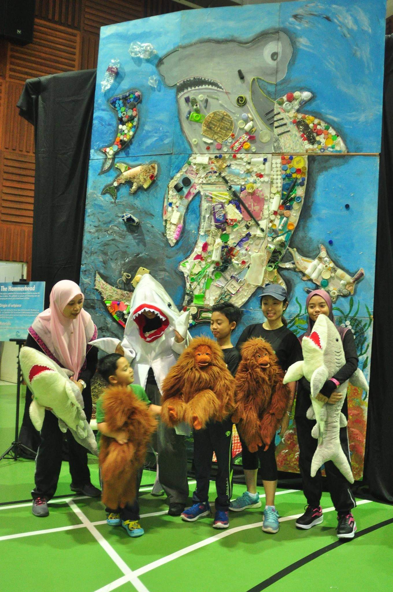 Children posing in front of the hammerhead shark made from trash collected from different beaches.