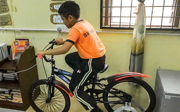 A young student from SK Salak uses pedal power to drive the generator.
