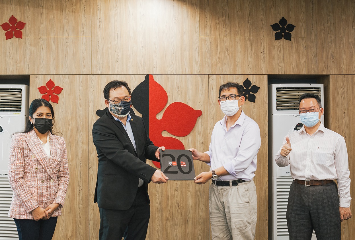 Prof Lau presenting Swinburne’s 20th anniversary coffee table book to Prof Chan witnessed by Prof Ida Fatimawati and Professor Law Ching Lim