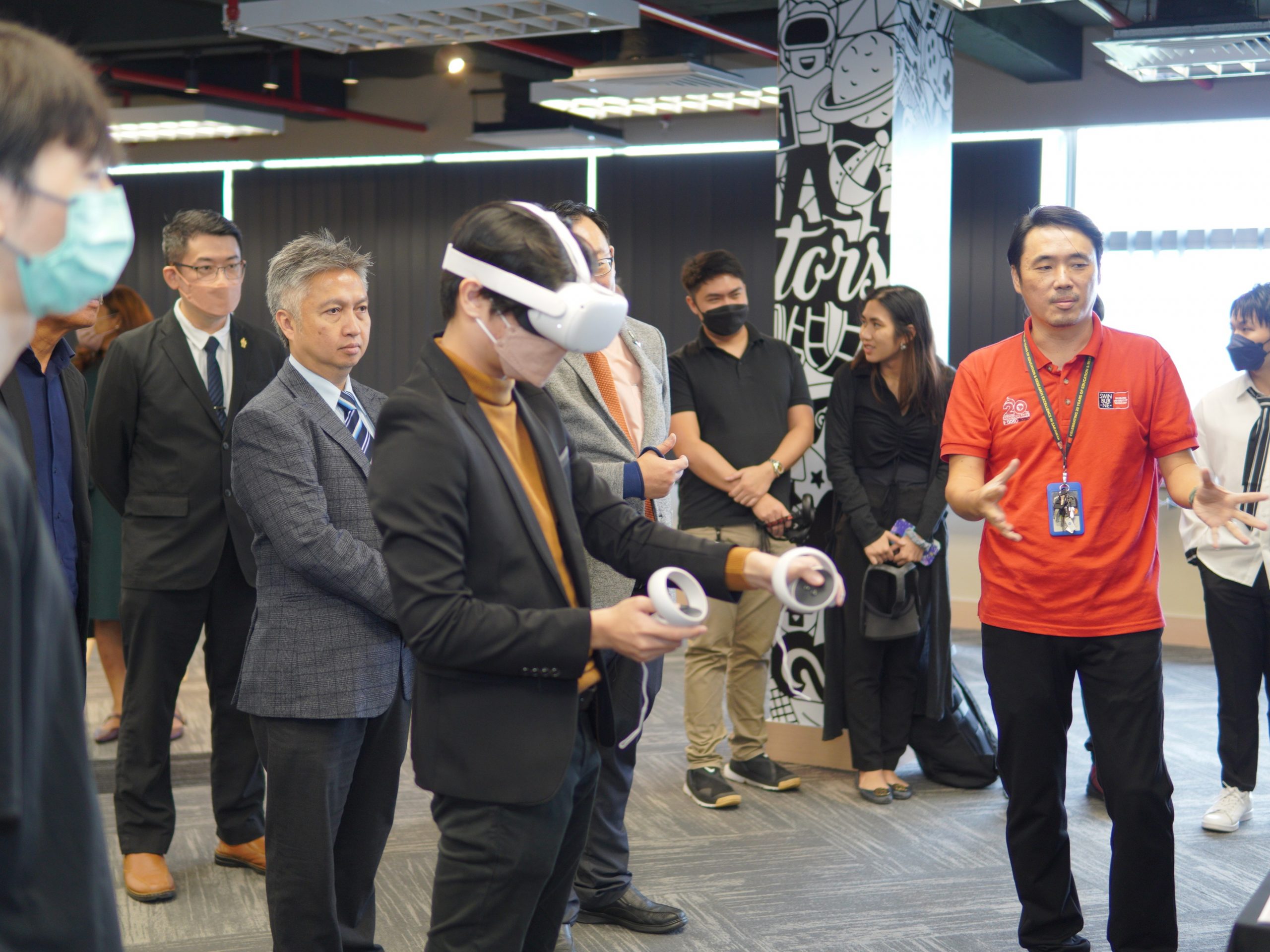 Datuk Snowdan (second left) and others observe as a Multimedia Design student demonstrates his Virtual Reality game project. 