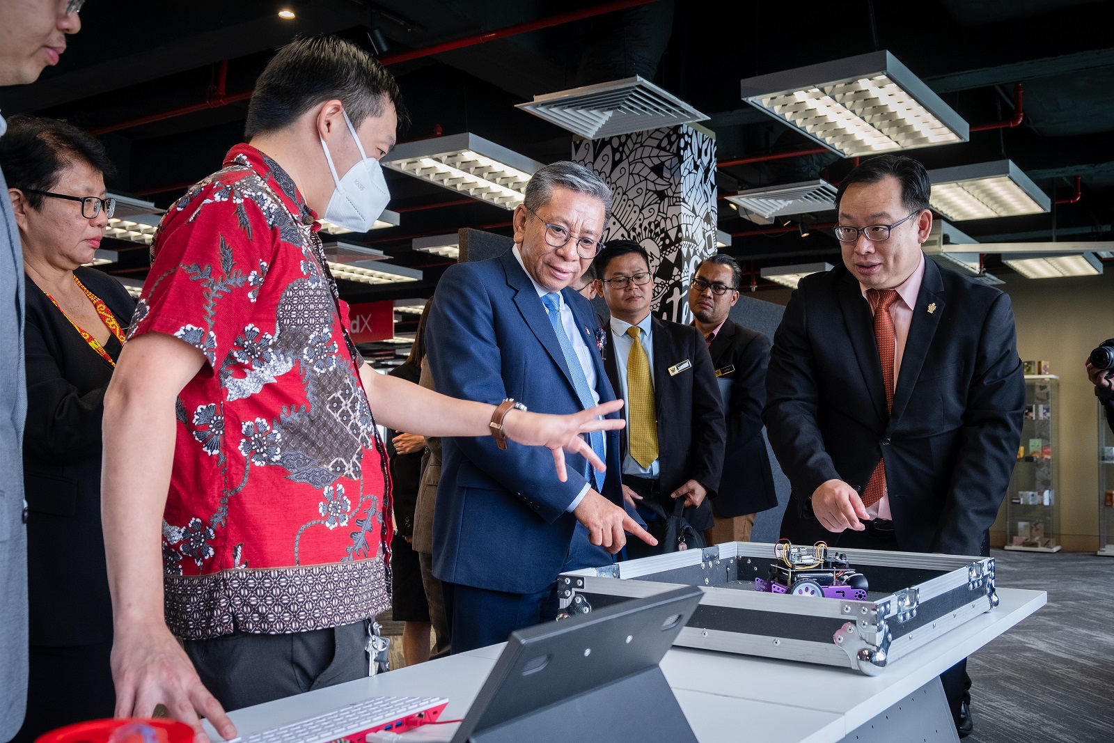 Dr Hudyjaya (left) showcases the Raspberry Pi system to Tuan Haji Azmi (centre) as Professor Lau (right) and others look on. 