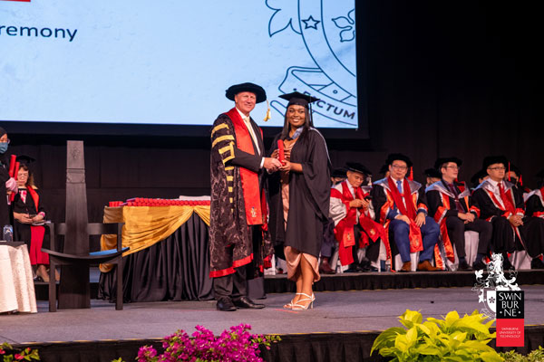 A student receives her scroll from Professor Pollaers.