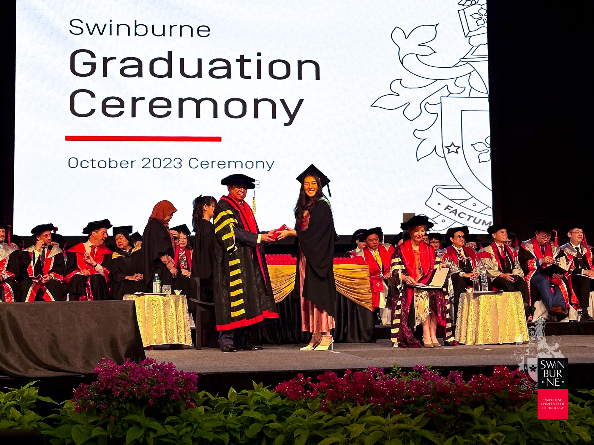 Datuk Patinggi Tan Sri (Dr) Abang Haji Abdul Rahman Zohari bin Tun Datuk Abang Haji Openg (front, left) presents a scroll to a graduate. 