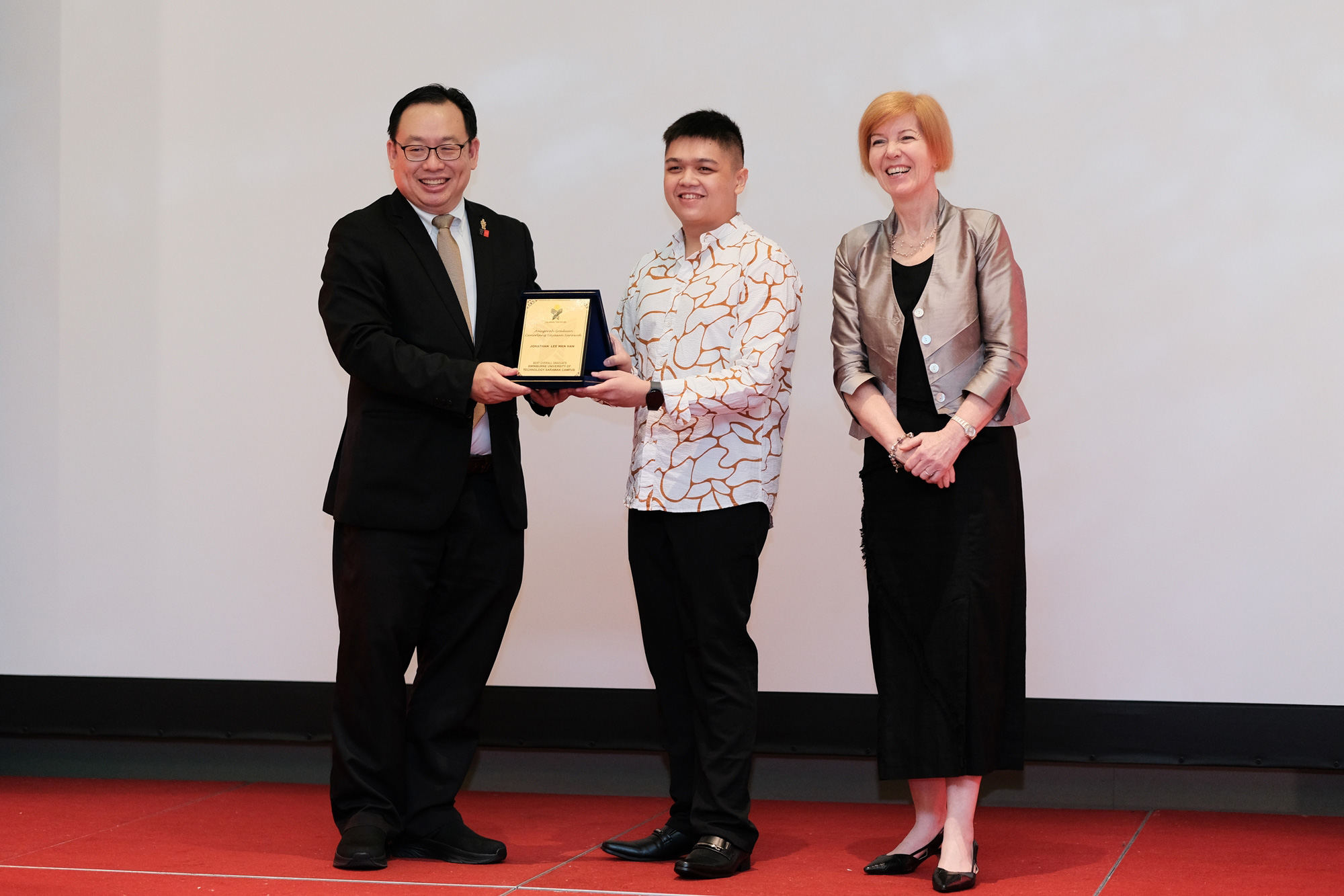 Jonathan Lee (centre) receiving the Sarawak Foundation's Outstanding Graduate Award from Ir Professor Lau Hieng Ho (left), witnessed by Professor Pascale Quester (right).