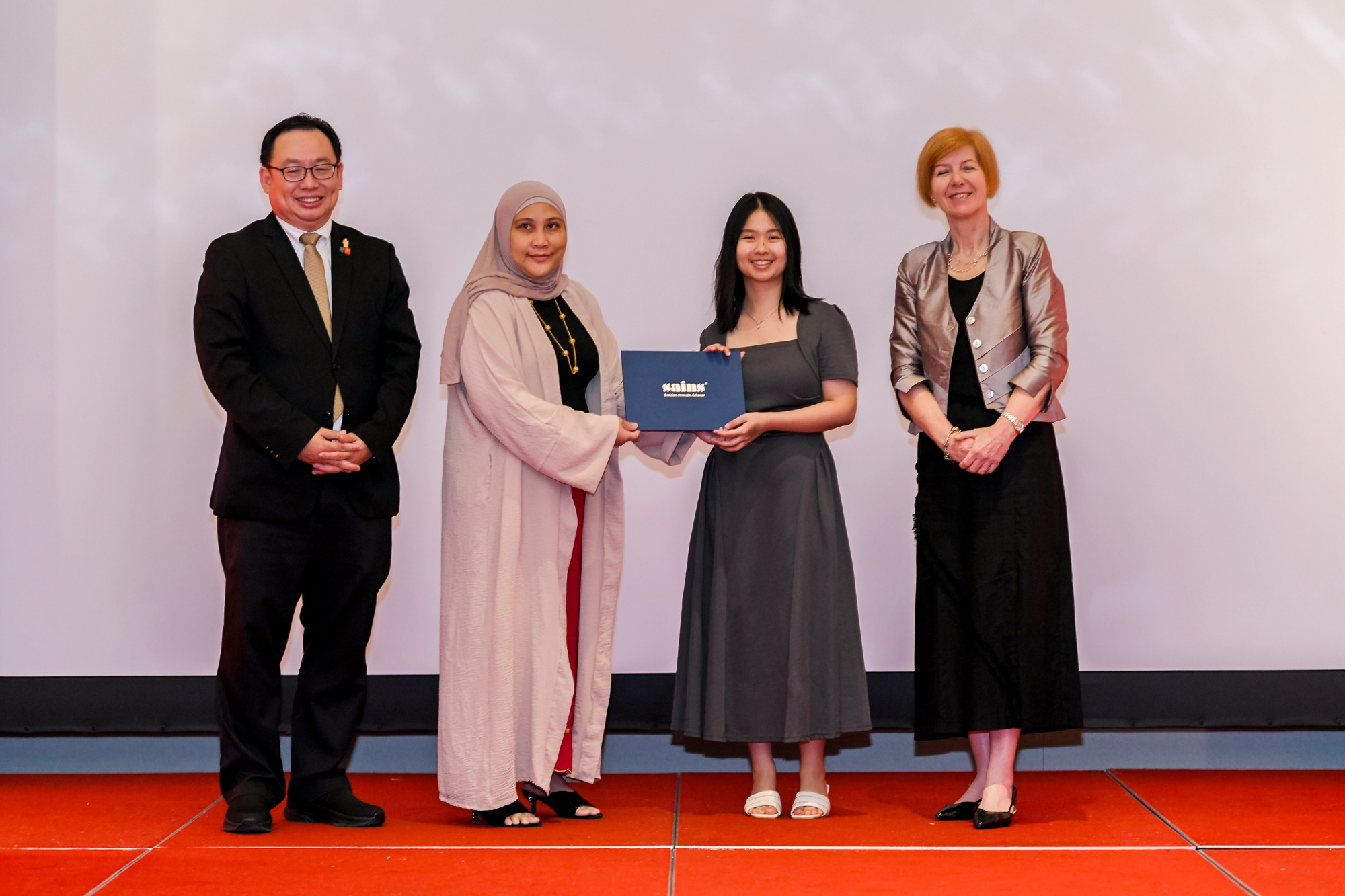 Rachel Soon (second right) receives the Best Graduate in Bachelor of Computer Science award from Ms Nadia Suhaili, Director of Customer Relationship Management at Sarawak Information Systems Sdn Bhd (SAINS), witnessed by Ir Professor Lau Hieng Ho (left) and Professor Pascale Quester (right).