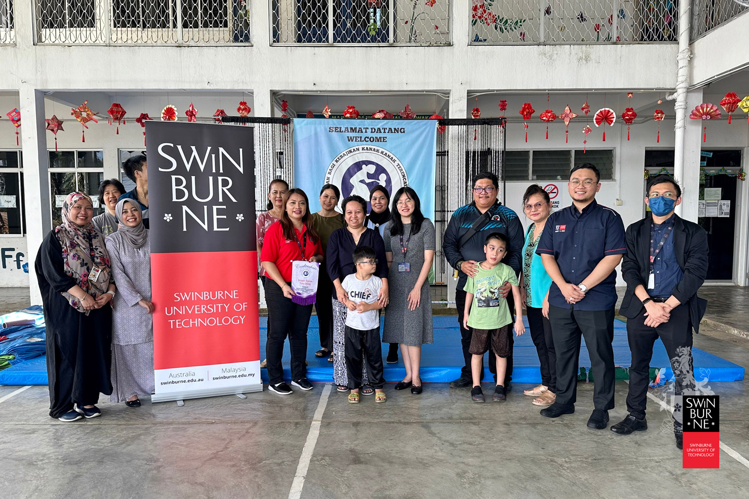 Leela Julong (front row, third left) and other members of Swinburne Sarawak Staff Recreational Club take a group photo with representatives from PERKATA Special School during the distribution of the bubur lambuk to external organisations.