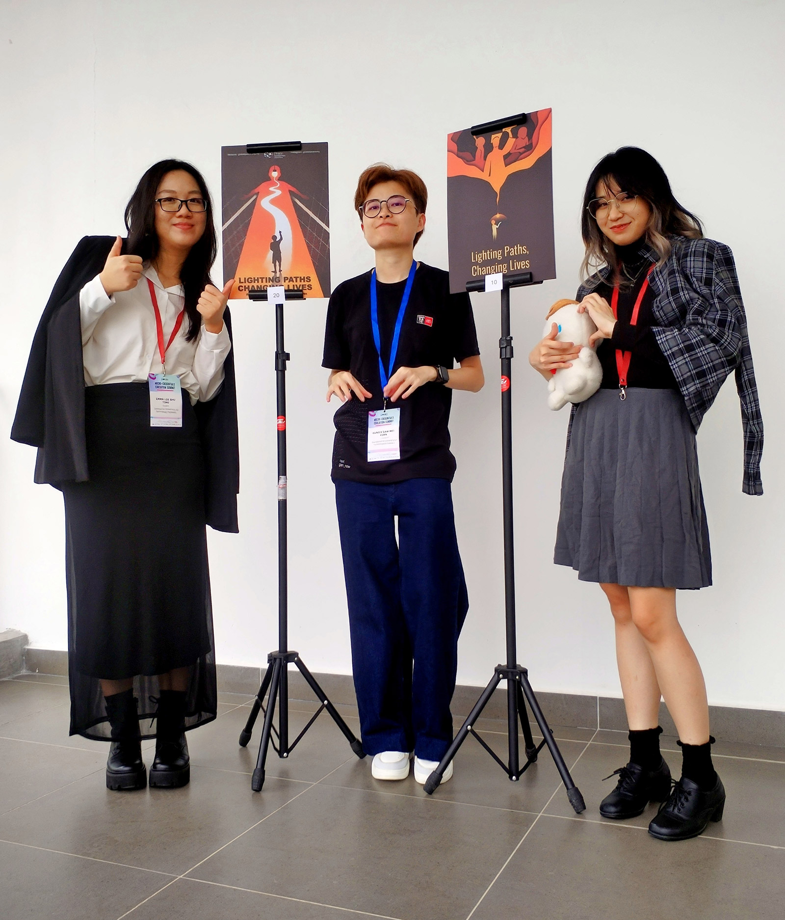 Eunice Law Mei Yuan (centre) along with Emma Lee Shu Ting (left), Rodney Ocean Bonardy, and their posters for the Adobe Certified Professional National Championship 2025 grand finale at the University of Cyberjaya.
