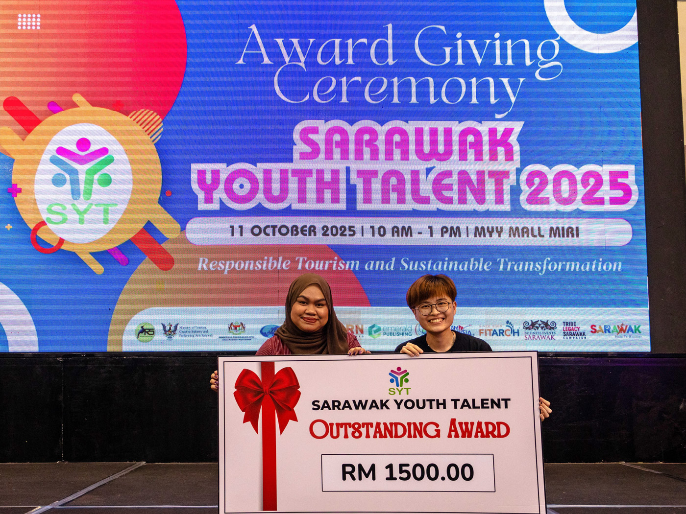 Aisya (left) and Law with the Outstanding Award.