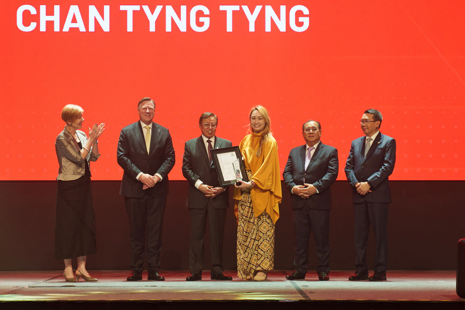 The Right Honourable Datuk Patinggi Tan Sri (Dr) Abang Haji Abdul Rahman Zohari bin Tun Datuk Abang Haji Openg (third left) presents the Distinguished Alumni Award to Chan Tyng Tyng (third right).