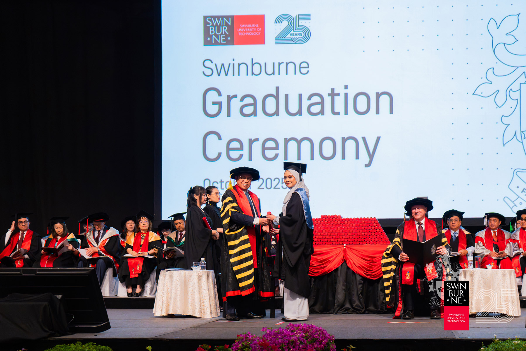 The Right Honourable Datuk Patinggi Tan Sri (Dr) Abang Haji Abdul Rahman Zohari bin Tun Datuk Abang Haji Openg (front, left) presents a scroll to a graduate.