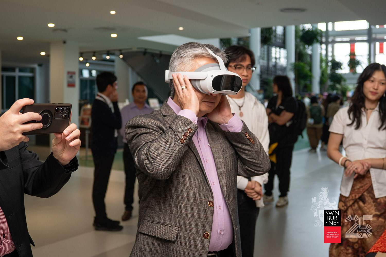 YB Datuk Snowdan Lawan immerses himself in a Virtual Reality (VR) experience at one of the student exhibitions.