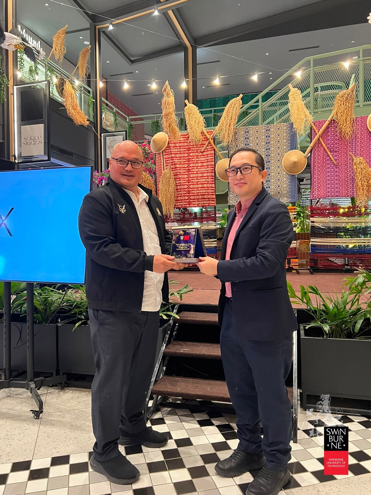 Raca Mulong (left) receives a token of appreciation from Professor Dr Brian Wong Kee Mun.