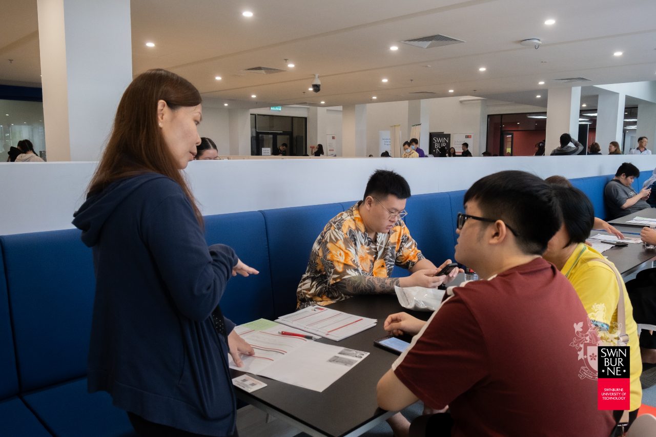 A Swinburne Sarawak counsellor explains FTES eligibility to a student and her parents during an Open Day briefing